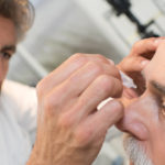 Ein Augenarzt bereitet einen Patienten auf die Glaukom Untersuchung vor