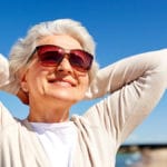 Eine Frau mit Sonnenbrille genießt die Sonne
