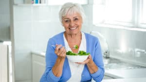 Eine Seniorin isst einen Salat