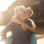 Zwei Senioren schützen Ihre Augen mit Sonnenbrillen vor der grellen Sonne am Strand